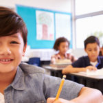 Boy in elementary school class looking to camera, Beach Cities Learning